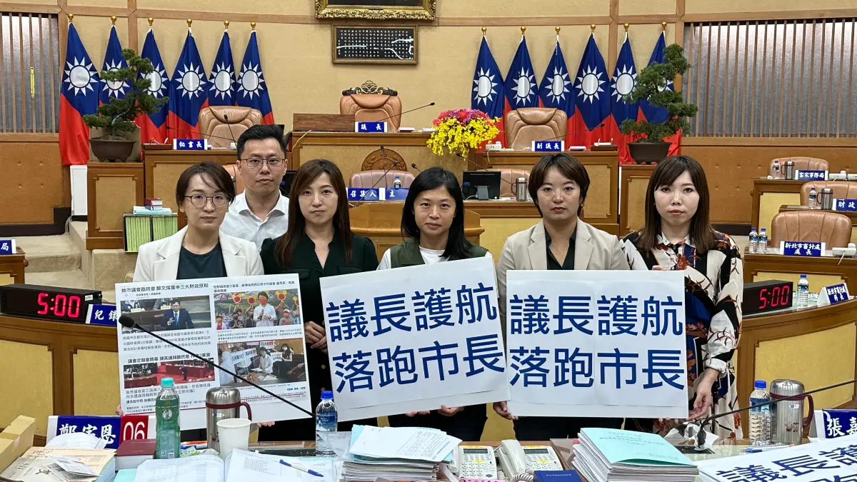 ▲為抗議昨日新北市議會臨時會提早散會，民進黨團今日在開議後發動清點人數時集體退席抗議導致散會，民進黨團在議場內舉手板表達抗議。（圖 ／新北市議會民進黨團提供）