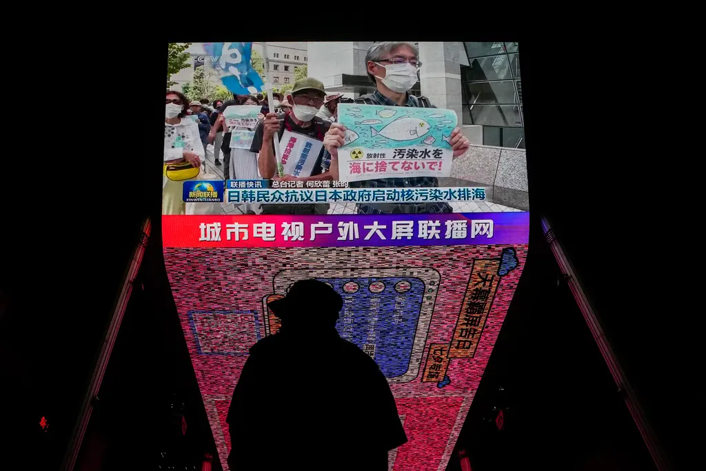 ▲日本朝日電視台今天報導，在印度舉行的20國集團（G20）峰會上，中國並未針對福島第一核電廠「核處理水」排放入海批評日本。對此，日本政府正慎重分析中方意圖。圖為中國民眾觀看日韓民眾抗議核廢水排海新聞。（圖／美聯社／達志影像）