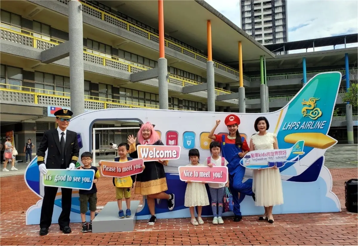▲龍華國小校長張瑞宜一早帶領LHPS AIRLINE機長與行政團隊，以及小朋友最喜愛的動畫人物安妮亞、馬利歐、路易吉在校門口迎接小一新生。（圖／高雄市教育局提供）