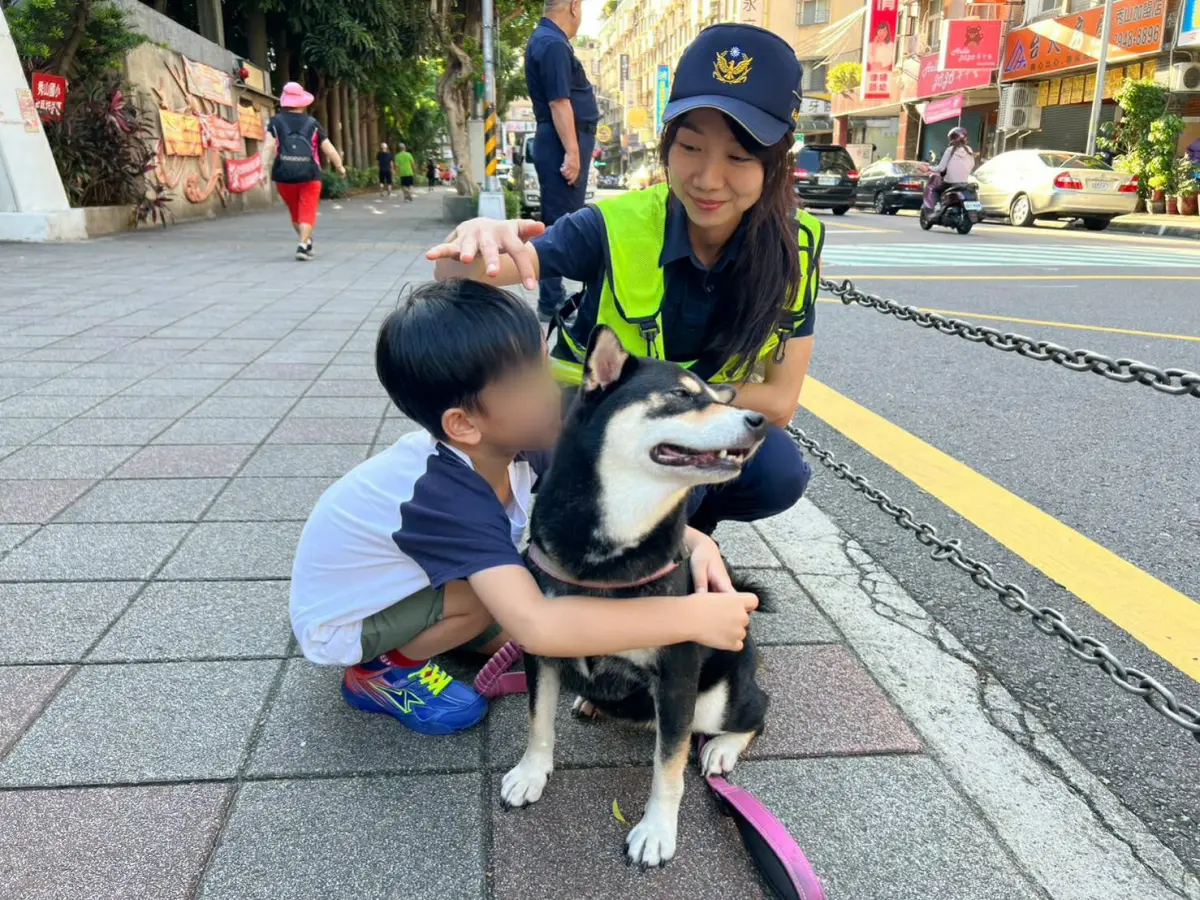 ▲中和警分局女警宋妤姍安撫帶著柴犬不敢入校的小一男童。（圖 ／新北市政府警察局局中和分局提供）