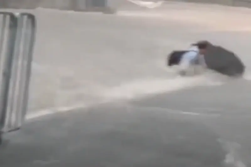 ▲受到海葵颱風殘餘環流影響，香港多地暴雨成災，一位西裝男子直接在馬路上被激流沖走。（圖／翻攝自車CAM追蹤＠YouTube頻道影片）