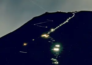 ▲即使在夜晚也能看見登山客為了看日出，摸黑登頂富士山，登山頭燈則照出了一條人龍。（圖／美聯社／達志影像）