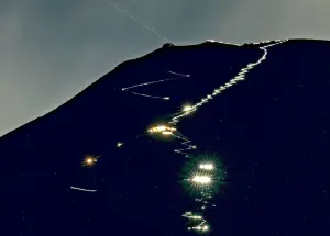 富士山登山季 ▲即使在夜晚也能看見登山客為了看日出,摸黑登頂富士山,登山頭燈則照出了一條人龍。(圖/美聯社/達志影像)