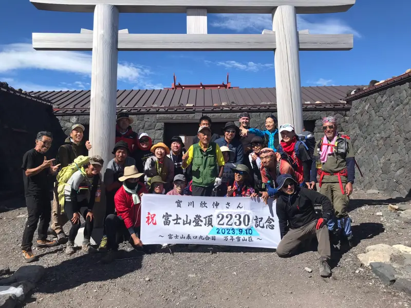 ▲「富士山先生」實川欣伸與山友們拉起布條慶祝登頂2230次。（圖／翻攝自推特@jitukawa37761）