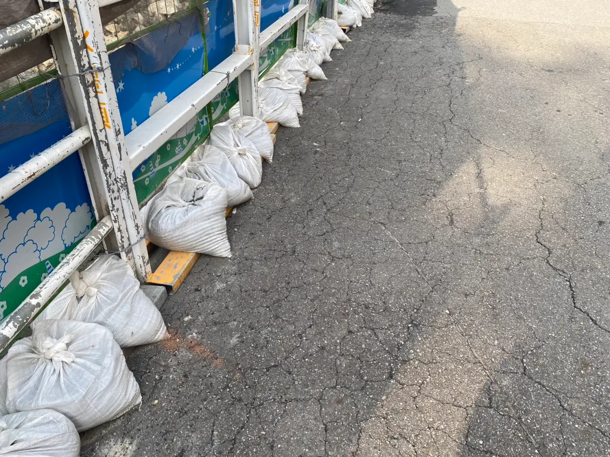 ▲南港區東新街77巷興合力建案今（12）日傳出地面下陷，馬路龜裂長達30公尺，相關單位獲報後趕抵現場勘查，根據初步了解，疑似塌陷處為水溝範圍，由於因重型機具進入導致下陷狀況。（圖／翻攝畫面）