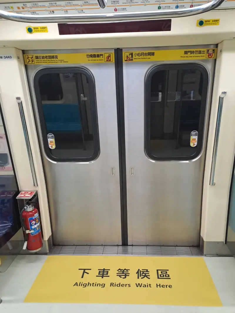 ▲從8月1日開始，試辦改裝中和新蘆線2部列車內多了「請往車廂內部移動」、「下車等候區」宣導指標，提醒民眾乘車時，盡量往車廂內部移動，將車門前空間禮讓給準備下車的旅客。（圖／台北捷運提供）
