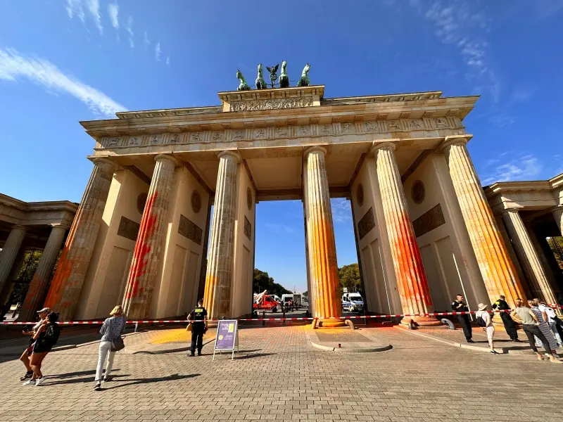 ▲德國首都柏林地標布蘭登堡大門的立柱被抗議氣候變遷的社運人士噴灑黃色和橙色油漆。（圖／美聯社／達志影像）