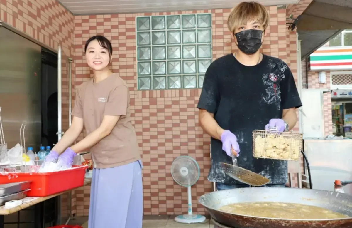 ▲近期掛上「兒子考上國立嘉義大學，鹽酥雞整年買一送一」紅布條在網路爆紅的桃園炸雞店，老闆娘張小姐（右）現身活動會場。（圖／嘉義大學提供）