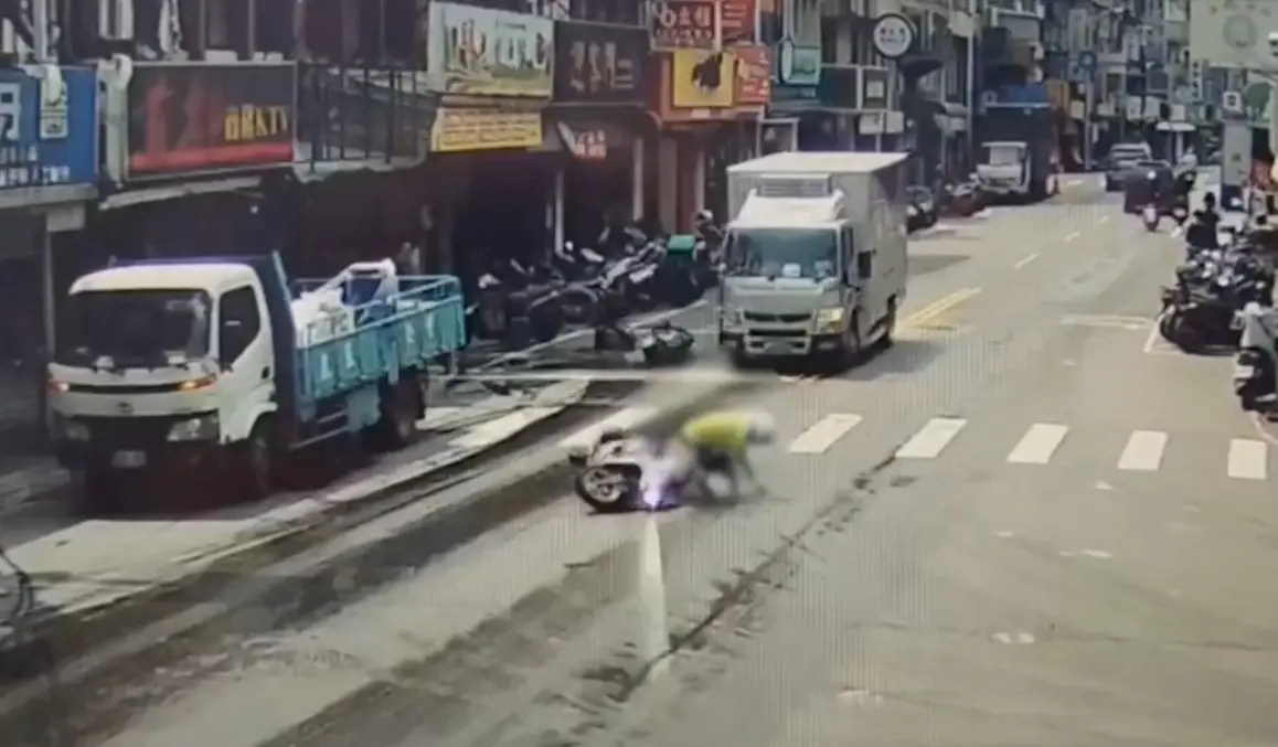 ▲貨車裝載潤滑油桶傾倒灑滿地，機車騎士行經滑倒摔車。（圖 ／翻攝畫面）