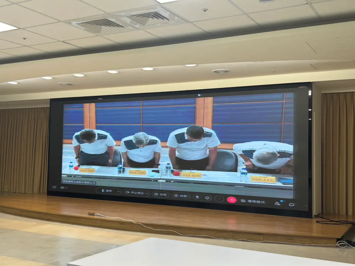 ▲屏東加工出口區高爾夫球代理廠「明揚國際」22日爆炸起火，造成超百人傷亡，母公司明安董座今（24）日透過視訊召開重大訊息記者會，高層於會前鞠躬致歉。（圖／記者鄭妤安攝影）