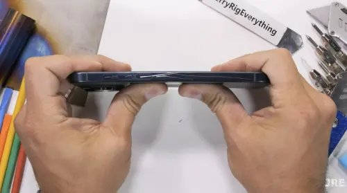 ▲「JerryRigEverything」橫握iPhone 15 Pro Max，從中間用力一折，不到3秒玻璃背蓋就應聲碎裂。（圖／翻攝自「JerryRigEverything」YT）