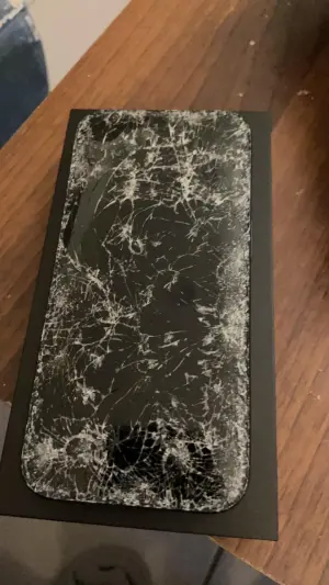 ▲出事的iPhone 15 Pro藍鈦合金正面螢幕布滿碎痕，左上角處更是呈現屏幕碎到凹陷的狀況。（圖／翻攝爆廢公社公開版臉書）