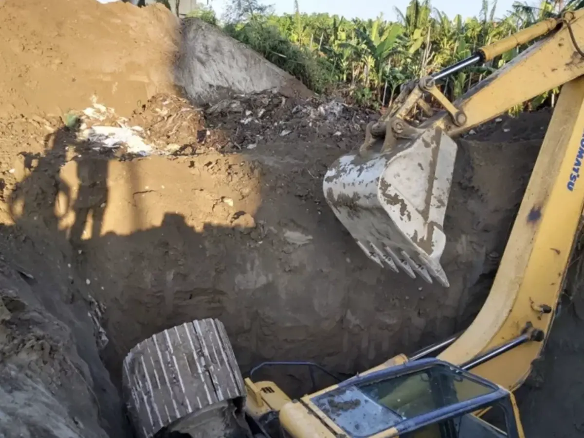 ▲高雄旗山區溪洲大橋下今（28）日生挖土機翻落土坑案件，一名工人疑似操作不慎，連人帶車掉落土坑慘遭掩埋，消防局出動7車24人前往搶救，消防隊救出已經失去生命跡象。（圖／翻攝畫面）