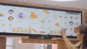 ▲消費者可在1.5m的巨型電子螢幕上滑選菜單，並能同時接受2人點餐。（圖／壽司郎提供）