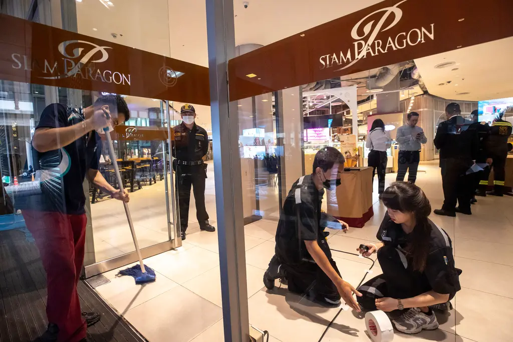 ▲泰國曼谷市中心的暹羅百麗宮（Siam Paragon）3日發生2死5傷的槍擊案，13日再傳出其中1名傷者就醫後拖十日死亡。圖為相關人員仔細地清理現場。（圖／美聯社／達志影像）