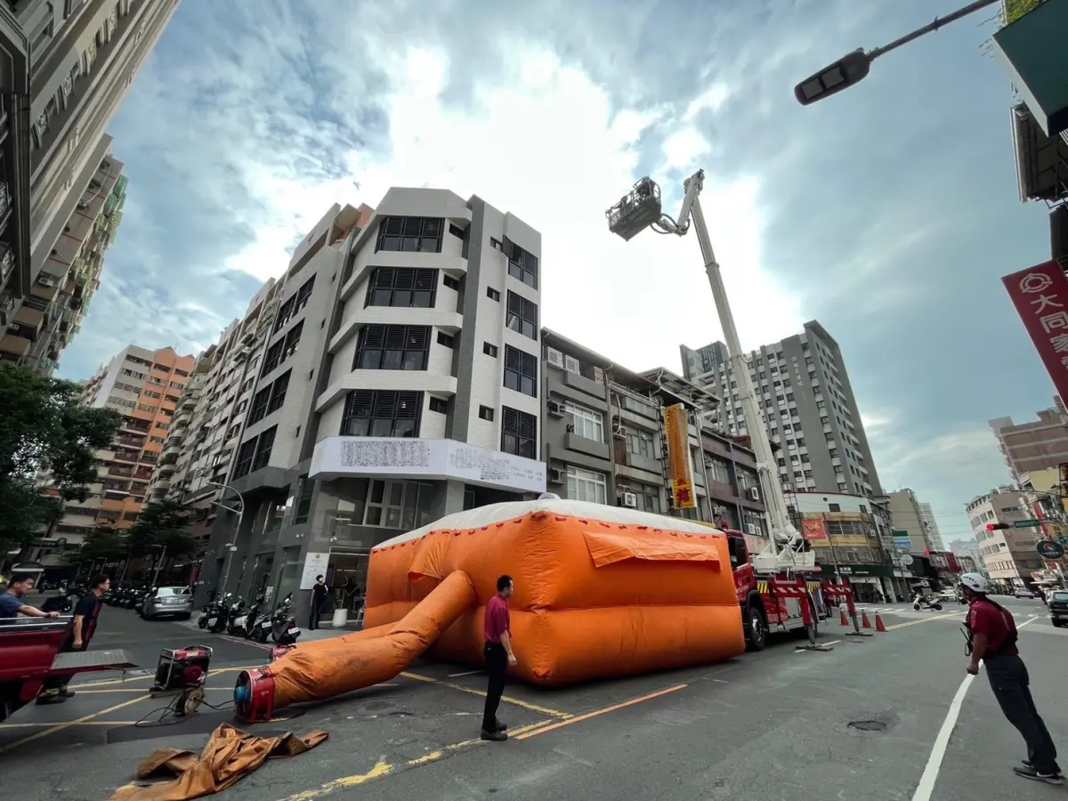 ▲警消獲報有男子爬出大樓窗外，急備充氣墊在樓下戒備。（圖／翻攝畫面）