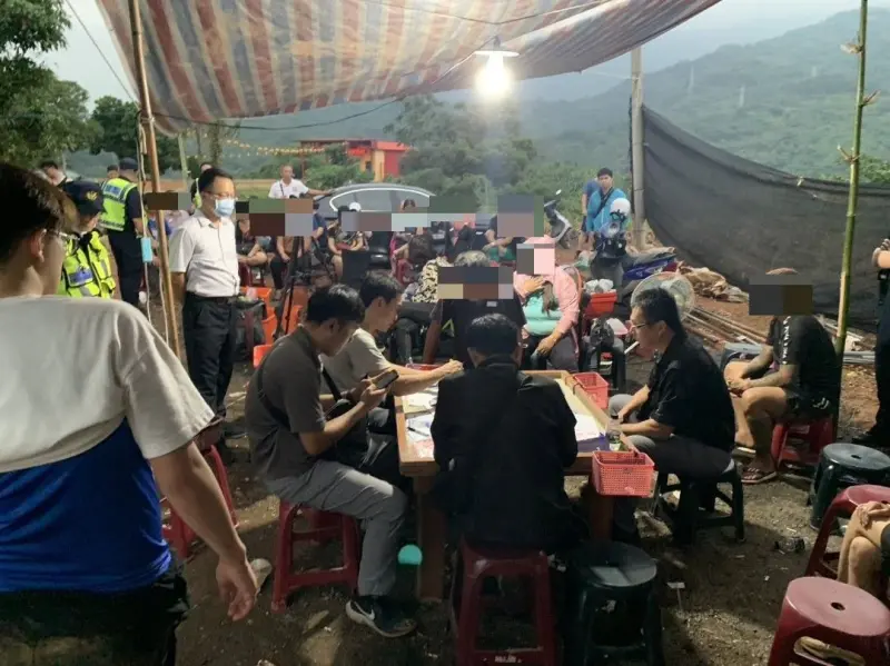 ▲警方在屏東新埤鄉餉潭村山上一處寺廟旁工寮查獲20多人聚賭。（圖／翻攝畫面）