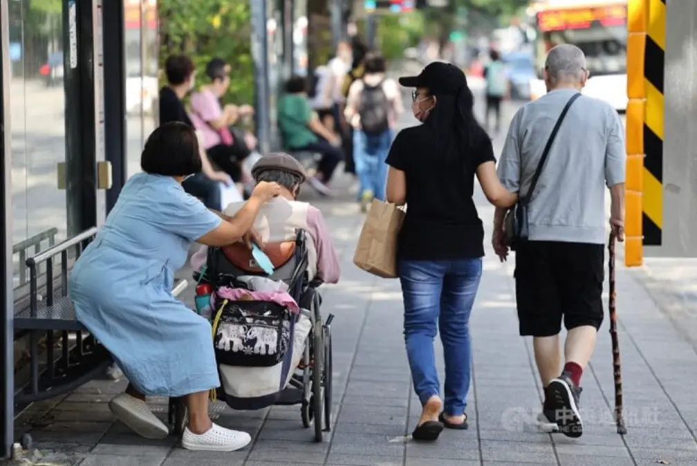 ▲ 圖為台北市中正區街頭看護與受照顧長者一同外出。（中央社檔案照片）