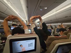 ▲網紅「布萊N機票達人」分享長途飛機時，即將抵達目的地一堆人都跟著螢幕做伸展操，畫面相當有趣。（圖/布萊N機票達人臉書）