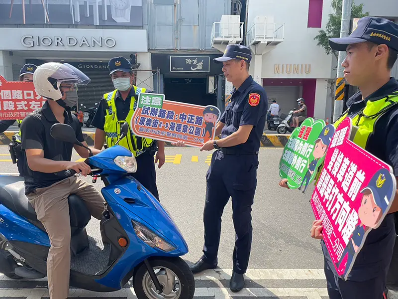 ▲台南市警察局第二分局員警在中正路與國華街口舉牌提醒騎士10/28起中正路和府前路各路口可直接左轉（圖／台南市警察局第二分局提供）