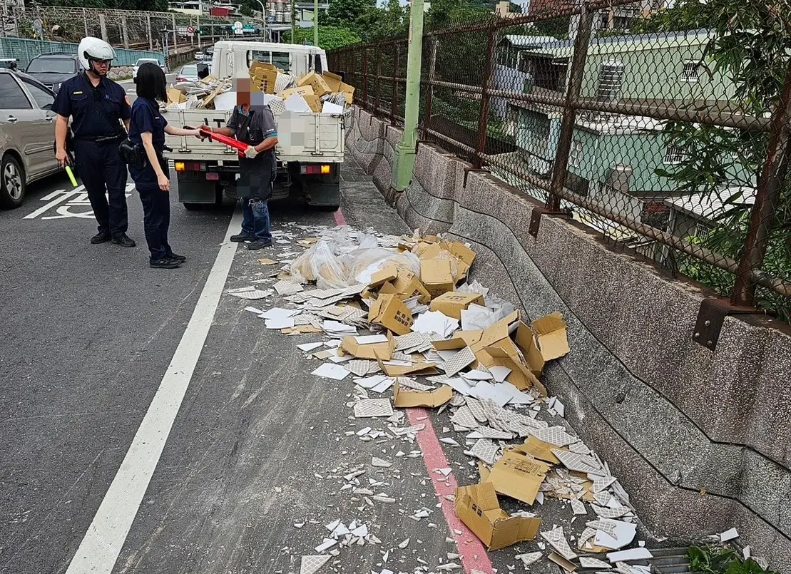 ▲黃姓小貨車駕駛不慎將滿載磁磚的紙箱掉落到路面，警方協助警戒並合力清除碎片。（圖 ／新北市警察局樹林分局提供）
