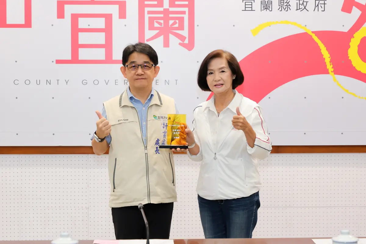 ▲宜蘭縣政府計畫處長王建源將獲永續城市優等獎的獎座獻獎給林姿妙。（圖 ／宜蘭縣政府提供）