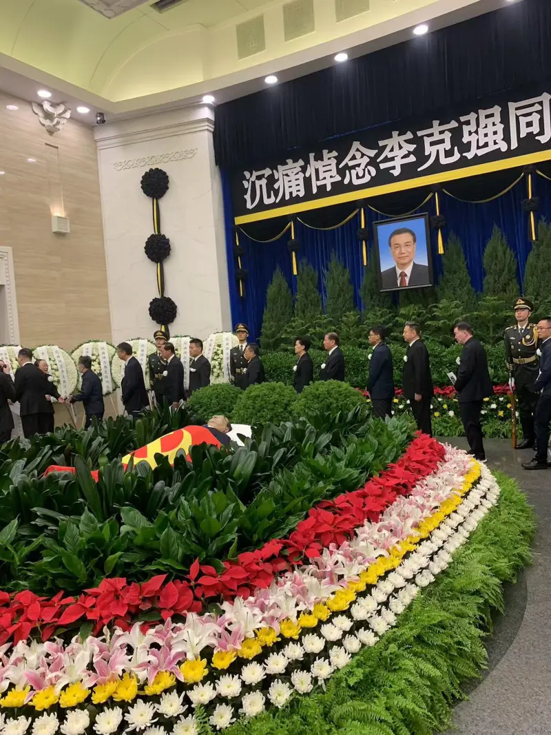 ▲八寶山正廳懸掛著黑底白字的橫幅「沉痛悼念李克強同志」，李克強的遺體則安臥在鮮花翠柏叢中，身上覆蓋著中國共產黨黨旗。（圖／翻攝自微博）