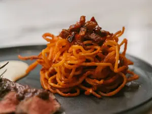 ▲刺客義大利麵(Spaghetti all' Assassina)為1960年代源自義大利南部普里亞大區首府巴里的風味料理，另外也可加價搭配柴窯火腿，更噴香宜人。（圖／PASTAIO提供）