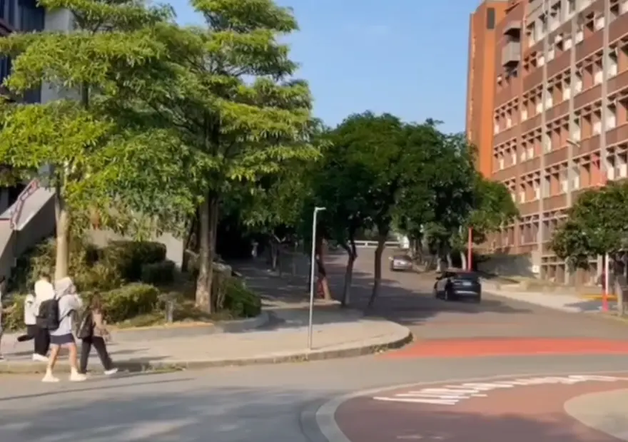 ▲今（2）日下午，桃園市龜山警方在查緝一輛可疑自小客車時，該輛小客車竟突衝進國立體育大學的校園內，警車隨後跟上，雙方在校園內展開飛車追逐，小客車在校內不斷飆車逃竄，開進一處死路後，員警跳車甩棍敲打對方的擋風玻璃和車窗，不過小客車駕駛仍趁隙加速駛離，校內學生目睹全程，被嚇得驚叫連連。（圖／翻攝社會事影音）