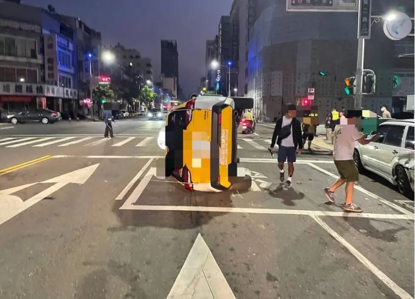 ▲4日清晨，高雄市前金區七賢二路與自強一路口，發生一起車禍事故，一台計程車不明原因失控追撞，波及路邊停放的2台自小客車，計程車整個側翻倒在路面。（圖／翻攝畫面）