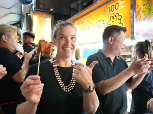 正港台灣味!盧秀燕帶AIT孫曉雅逛一中街 吃雞排比劃射氣球 ▲孫曉雅邊走邊吃大雞排,體驗台中的夜市文化。(圖/台中市政府提供,2023.11.05)