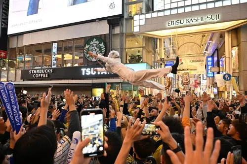 ▲阪神虎睽違38年日本一，球迷瘋狂慶祝，一名喬裝肯德基爺爺的球迷也被高拋丟下河。（取自f_old_kit推特）