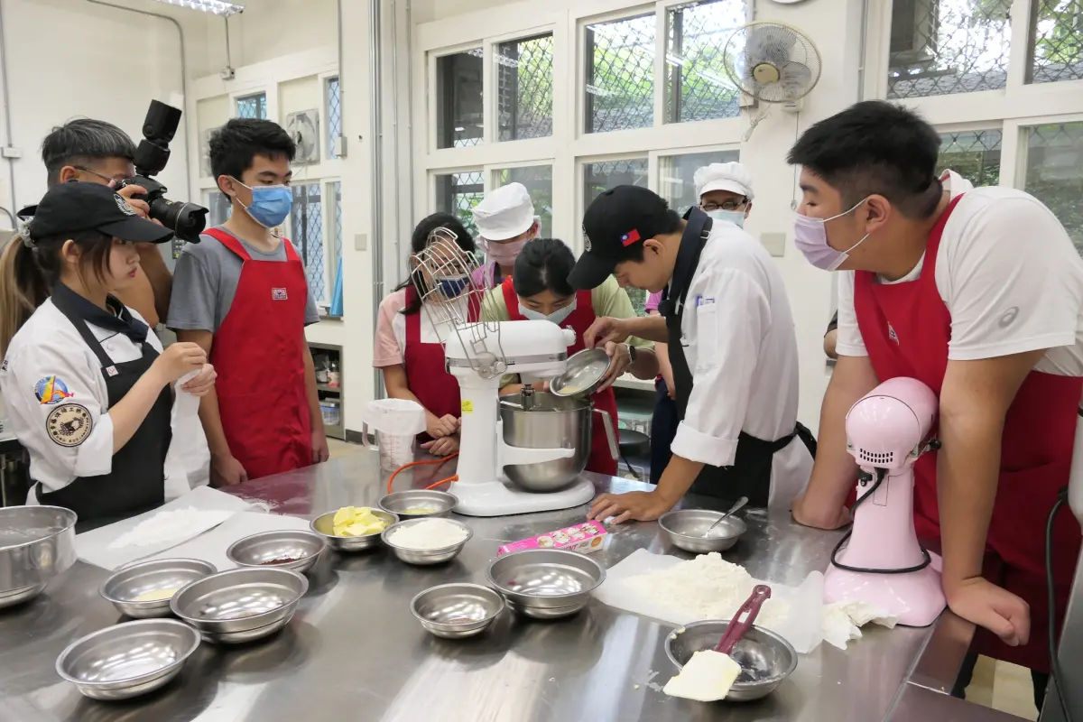 ▲台北市立啟明學校學生在醒吾科大餐旅管理系學生協助下，小心翼翼的倒入牛奶。（圖 ／醒吾科技大學提供）