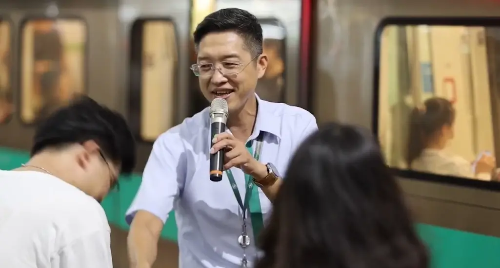 ▲英國搖滾天團Coldplay到高雄世運主場館開唱，有「被捷運耽誤的歌手」之稱的高雄捷運橋頭糖廠站站長林忠明今（11）日再度到世運站高歌，這次準備新歌單獻給等車的粉絲。（圖／翻攝畫面）