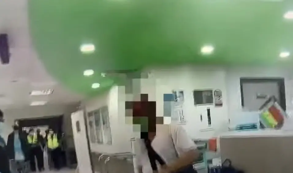 ▲高雄35歲吳姓男子，與小港醫院發生醫療糾紛，11日深夜，吳男酒醉竟手持菜刀，衝進醫院的護理站，對著醫師及護理師嗆聲、揮舞菜刀，最後被員警及醫院保全合力壓制，訊後移送高雄地檢署偵辦。（圖／翻攝畫面）