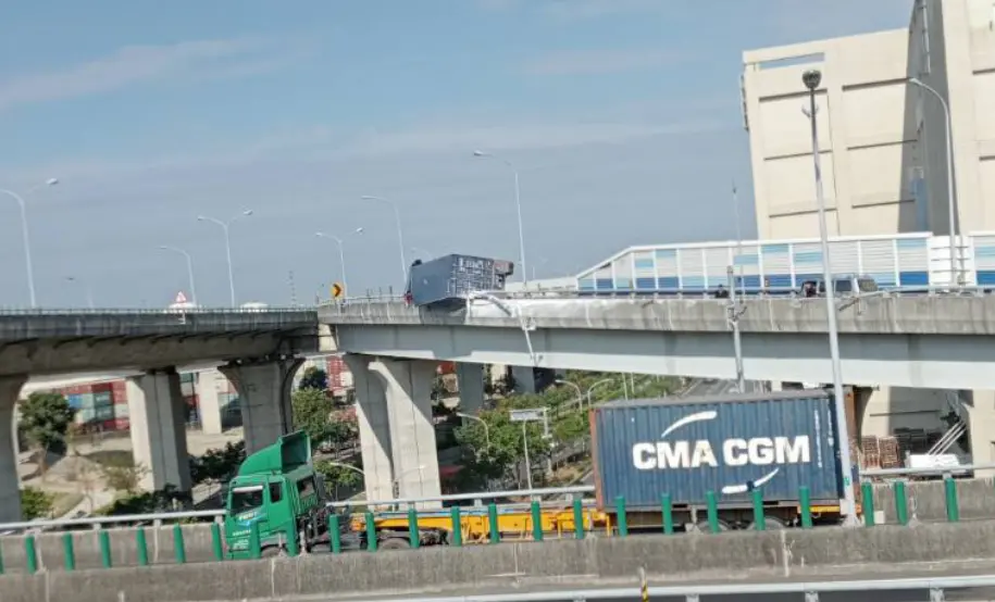 ▲貨櫃車翻覆，卡在橋邊護欄，場面相當駭人。（圖／翻攝自記者爆料網）