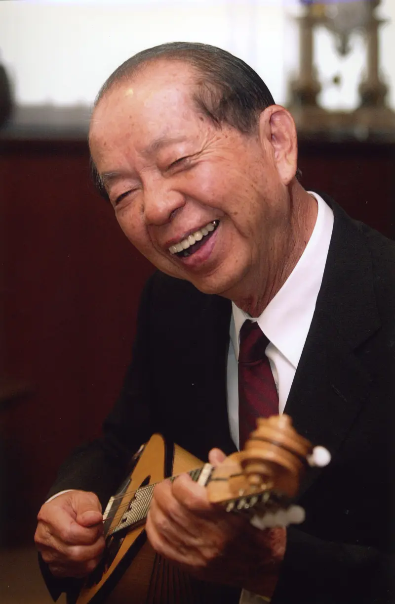▲許文龍一生致力為臺灣實現幸福感,照片為其閒暇愛好「彈奏曼陀林」。(圖/奇美實業提供)