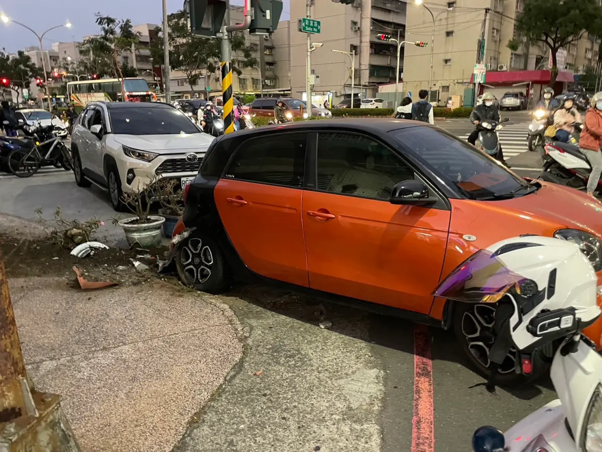 ▲高雄市1名高姓女子昨天下午開車，突然身體不適無預警將車「倒退嚕」，由於適逢下班時間，高女的自小客車僅撞上路旁的交通號誌桿及路邊的盆栽，未撞上其他人車。（圖／記者郭凱杰翻攝）