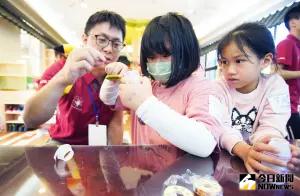 台積電慈善基金會的志工們,今天透過養樂多瓶子發電,指導小學生以漆包線纏繞養樂多瓶子,再架設強力磁鐵,手動旋轉強力磁鐵後,即點亮LED燈泡 ▲台積電慈善基金會的志工們,今天透過養樂多瓶子發電,指導小學生以漆包線纏繞養樂多瓶子,再架設強力磁鐵,手動旋轉強力磁鐵後,即點亮LED燈泡。(圖/記者李春台攝,2023.11.24)