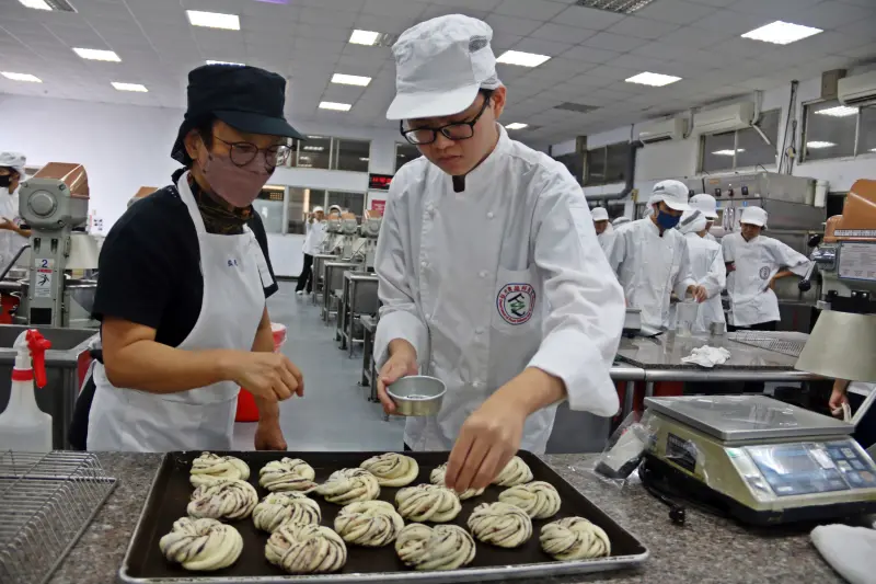 ▲弘光科大食科系一年級馬來西亞境外生黃子軒（右）上麵包實作課。(圖／弘光科大提供2023.11.27)