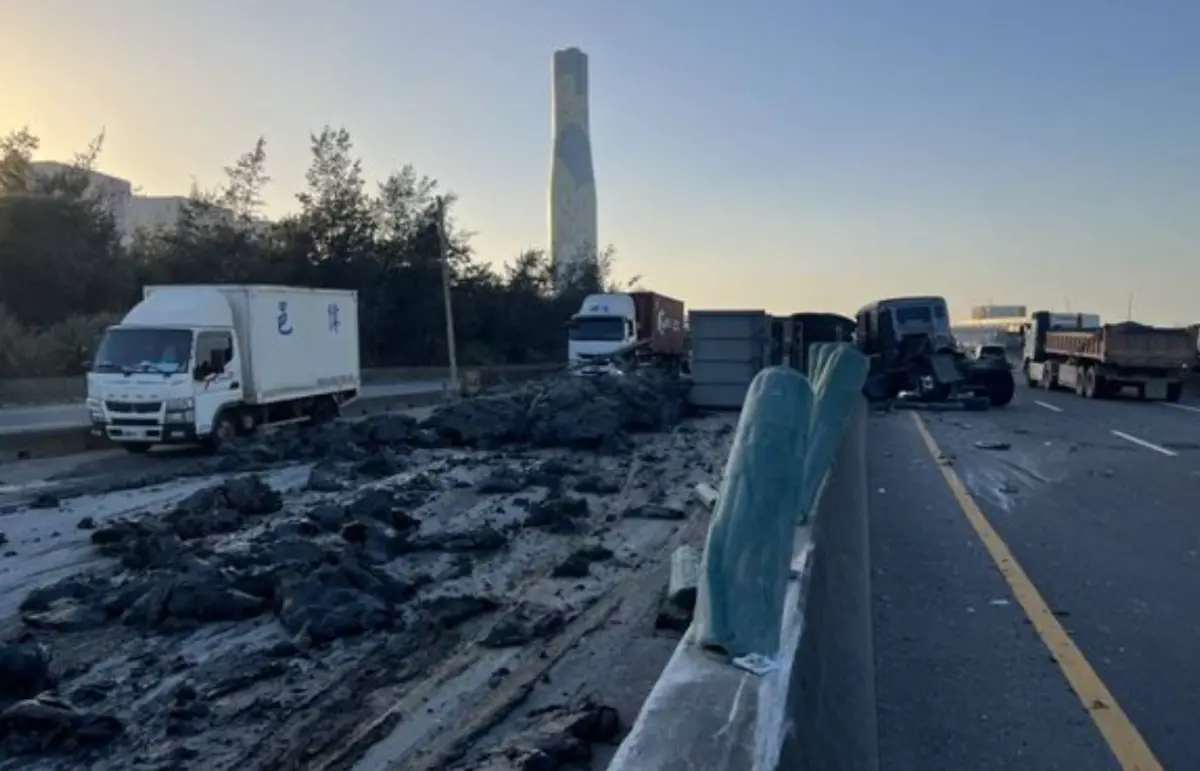 ▲今（28）日下午近4時，新北市一名22歲黃男駕駛駕駛砂石車行經台61線南下14.1K，車輛突然爆胎，導致車身失控不穩，隨後自撞分隔島，車上所載廢土灑滿車道，導致56歲廖姓重機騎士閃避不及摔倒，黃男與廖男雙雙送往林口長庚醫院，目前南北內線因廢土關係不能通行，詳細車禍情形仍待調查。（圖／翻攝畫面）