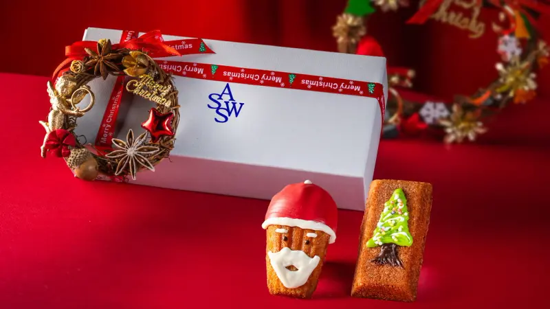 ▲聖誕節限定版費南雪禮盒，甜點師使用巧克力彩繪上聖誕樹與聖誕老人，公益款每一盒還附贈一個憨兒手作花圈。（圖／御盟集團提供）