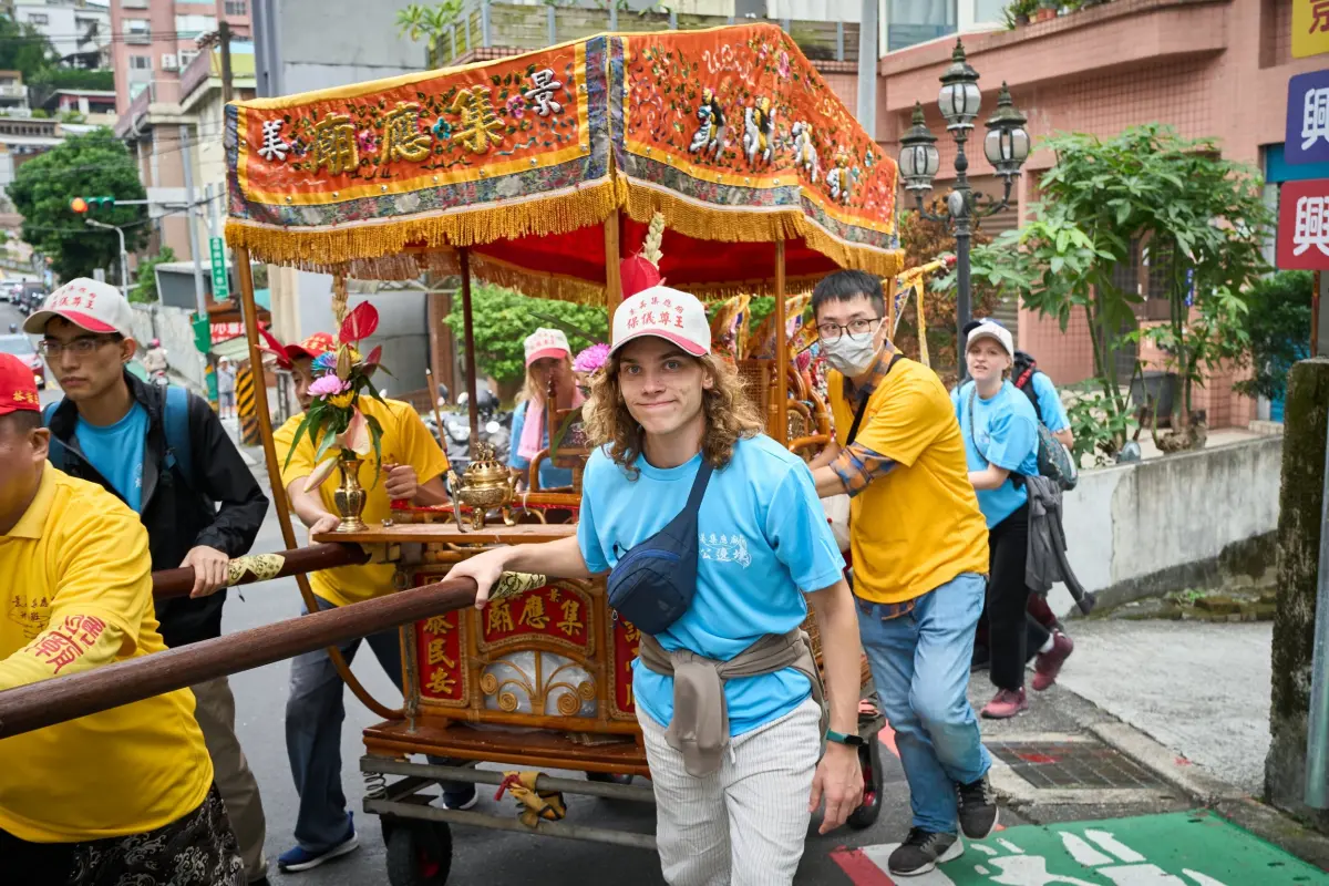 ▲60名政大國際生組「進香團」，抬神轎遶境體驗台灣廟宇文化。（圖／政大提供）