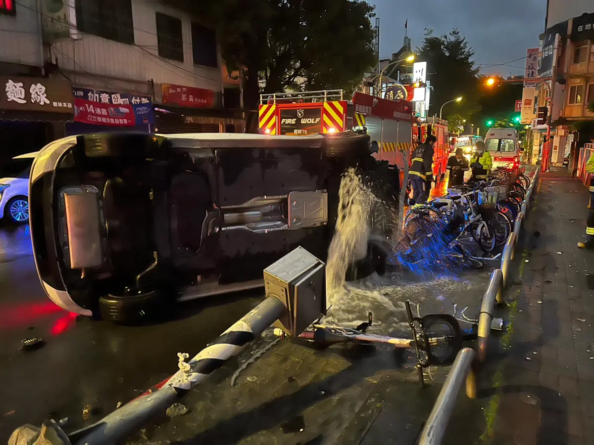 ▲男子開車疑似精神不繼自撞到路邊變電箱及消防栓，導致車輛翻覆，水勢從被撞倒的消防栓管口湧出。（圖 ／翻攝畫面）