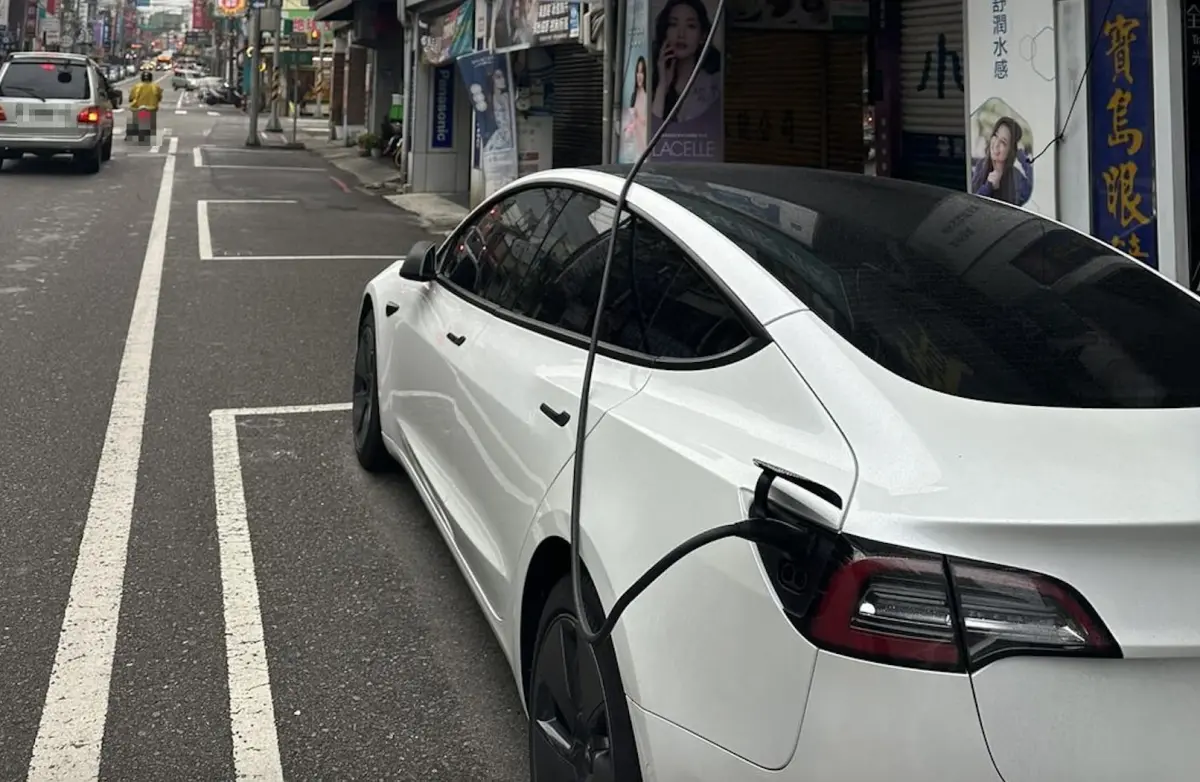 ▲近日一名網友目睹，有特斯拉車主將車停在路邊停車格，接著竟將充電線一路連接到一旁建築物2樓充電。（圖／翻攝臉書社團「路上觀察學院」）