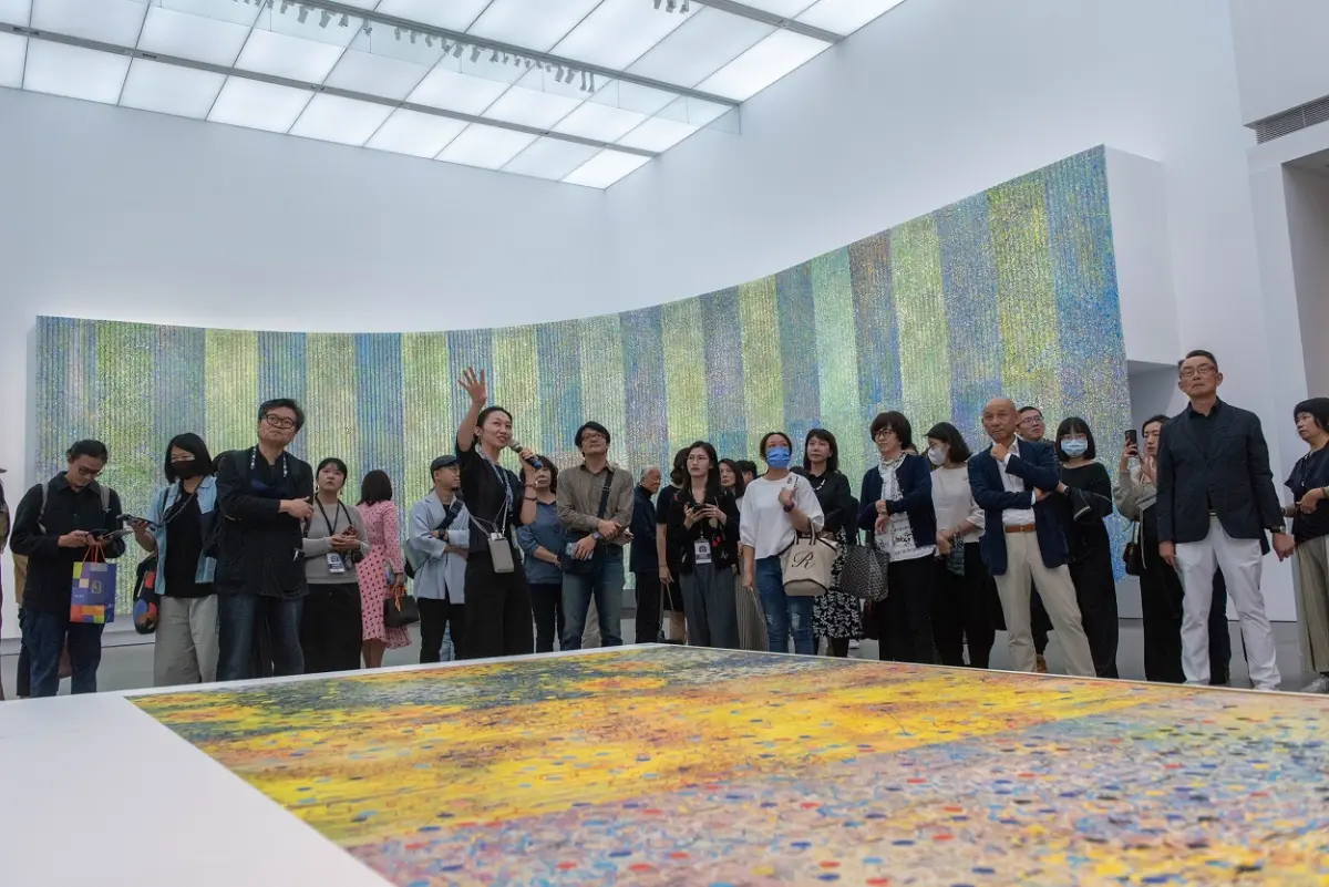 ▲高美館《江賢二2023個展》策展人崔綵珊（前左二）帶領開幕觀眾導覽，分享從「湛」為帶出江賢二作品中的「深厚」與「透亮」。(圖／高美館提供)