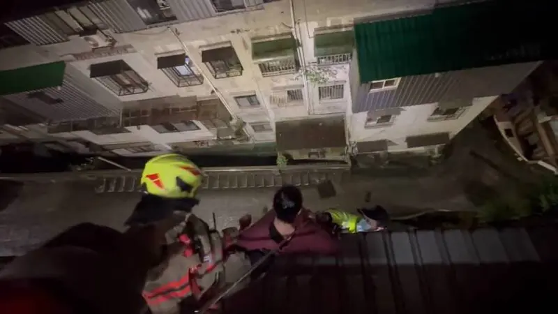 ▲基隆婦人在陽台收衣服不慎失足墜落遮雨棚，消防員趕往現場垂降救援。（圖／翻攝畫面）