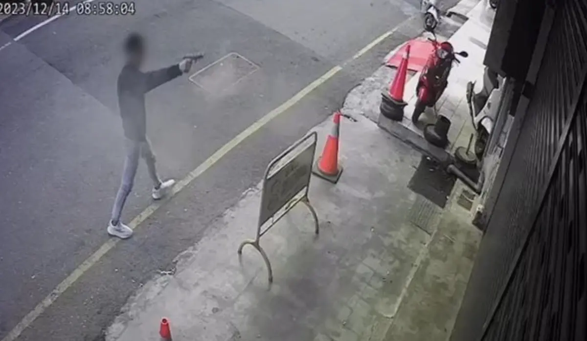 ▲今（14）日上午8時58分，光明路一間夜店遭人連續開槍，19歲的許姓男子先持改造手槍朝店家鐵門連開10槍，後續二度倒車撞爛店家鐵捲門，所幸無人受傷。（圖／翻攝畫面）