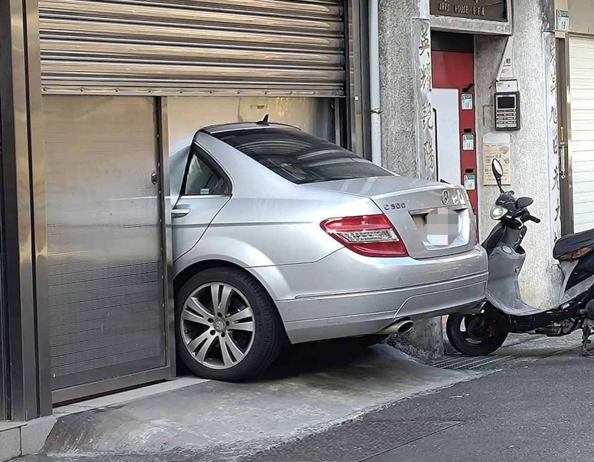 ▲一名汽車車主將自家透天1樓打造成車庫，卻因空間太小，而讓半個車屁股都露在屋外，他也找人特別訂製專屬鐵板來「關門」。（圖／翻攝自臉書社團「路上觀察學院」）