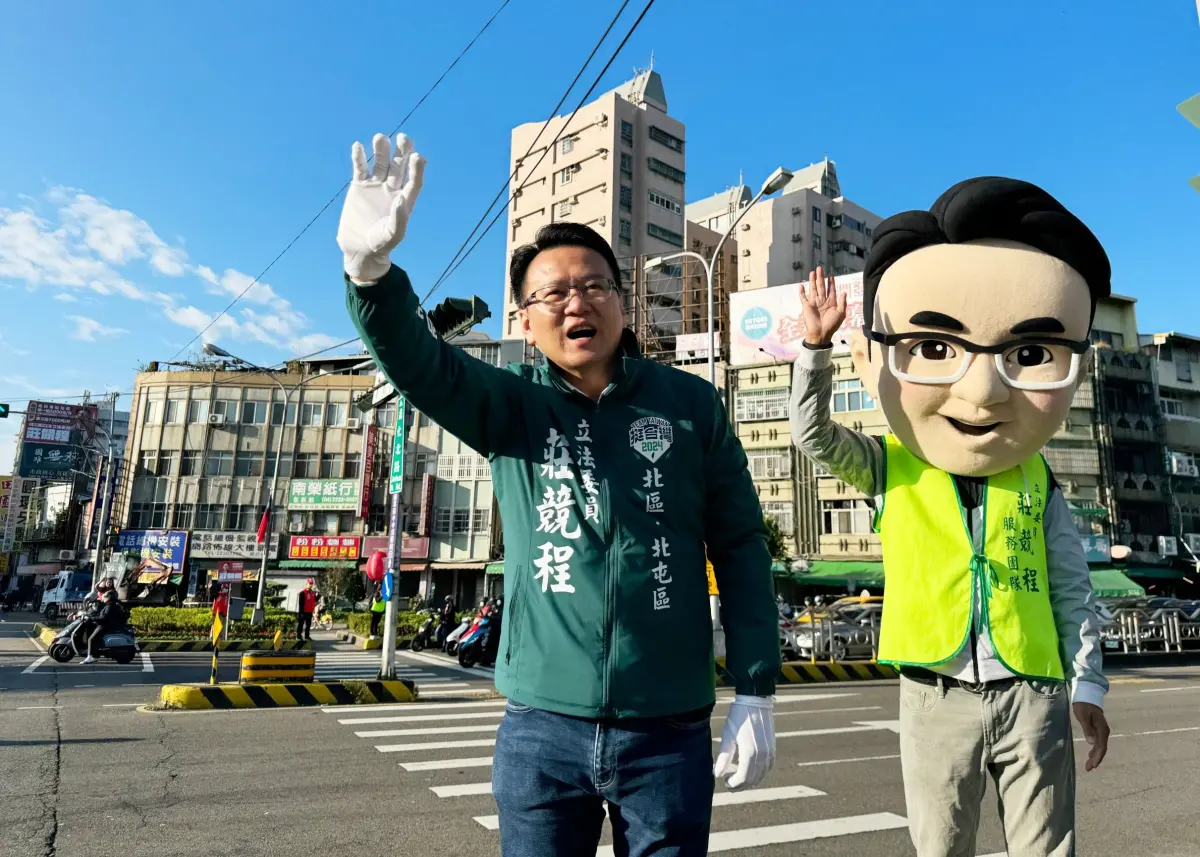 ▲尋求連任的民進黨北區、北屯區立委莊競程，為加深選民的印象，與Q版大頭娃娃站路口拜票(圖／莊競程提供2023.12.18)